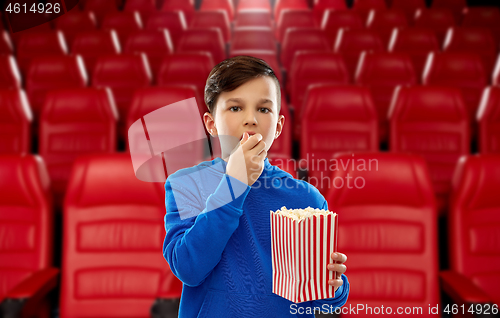 Image of boy in blue hoodie eating popcorn at movie theater