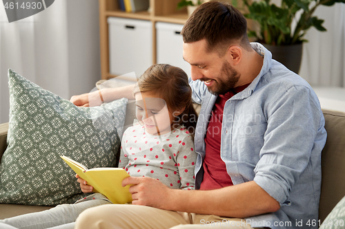 Image of happy father and daughter reading book at home