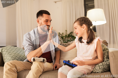 Image of father and daughter playing video game at home