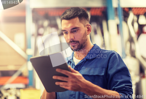 Image of auto mechanic or smith with tablet pc at workshop