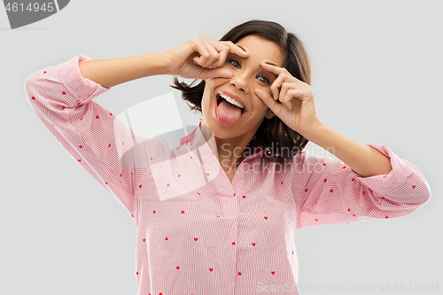 Image of happy young woman in pajama opening her eyes