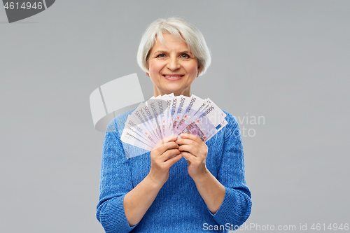 Image of senior woman with hundreds of euro money banknotes