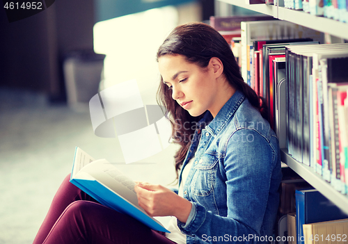 Image of high school student girl reading book at library