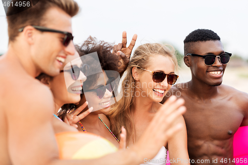 Image of happy friends in sunglasses on summer beach