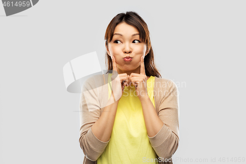 Image of smiling asian woman making faces and having fun