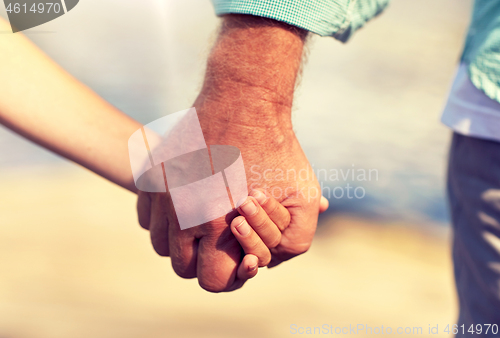 Image of senior man and child holding hands