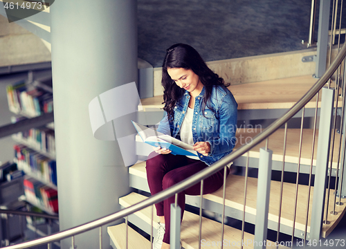 Image of high school student girl reading book at library