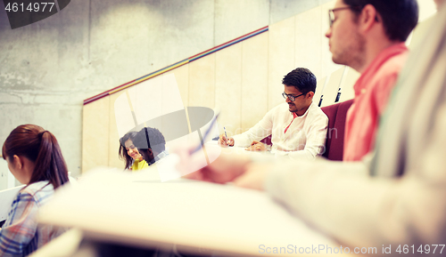 Image of group of students with notebooks in lecture hall