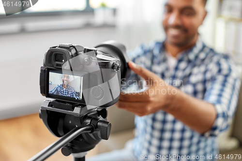 Image of close up of indian video blogger adjusting camera