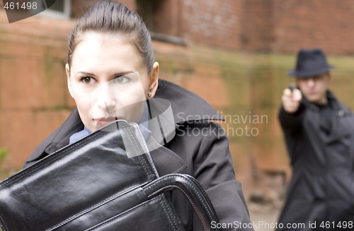 Image of man threatens the woman with a gun