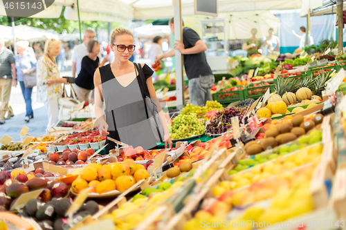 Image of Woman buying fruits and vegetables at local food market. Market stall with variety of organic vegetable