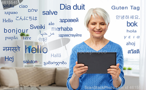 Image of senior woman using translator on tablet computer