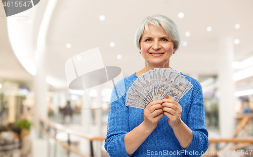 Image of senior woman with dollar money over shopping mall