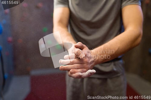 Image of male climber drying hands at indoor climbing gym