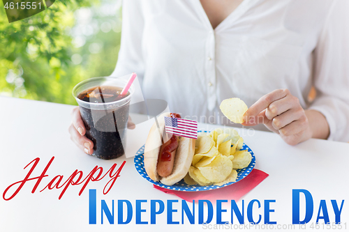 Image of close up of woman eating chips, hot dog and cola