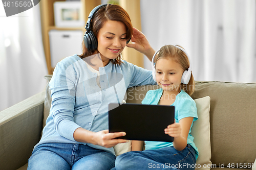 Image of mother and daughter listen to music on tablet pc