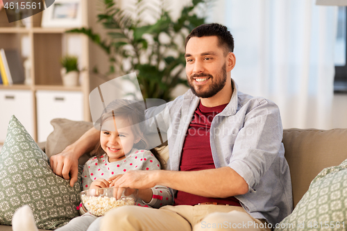 Image of happy father and daughter watching tv at home