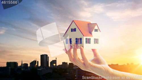 Image of close up of hand holding house or home model