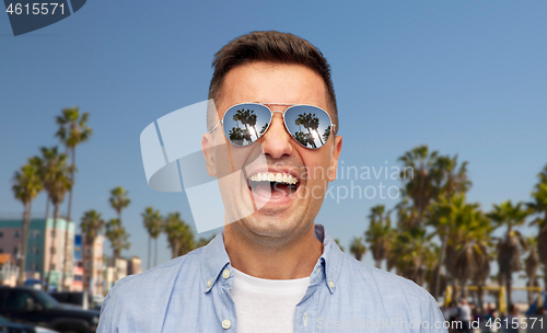 Image of laughing man in sunglasses over venice beach