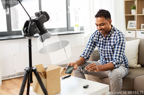 Image of male blogger with smartphone, wire and parcel box