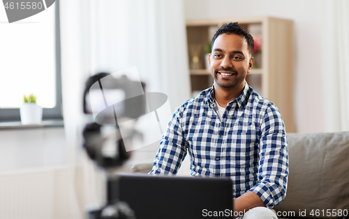 Image of male blogger with camera videoblogging at home