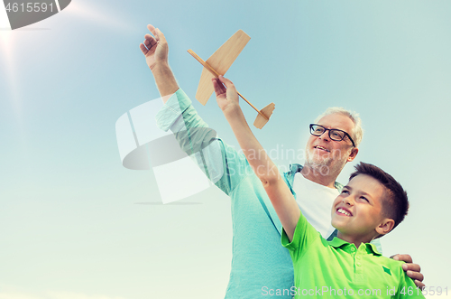 Image of senior man and boy with toy airplane over sky