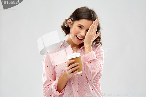 Image of happy young woman in pajama with cup of coffee