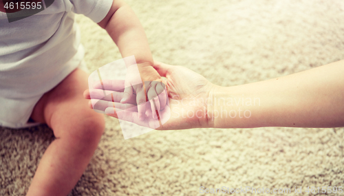 Image of close up of little baby and mother hands