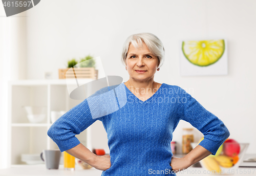 Image of senior woman with hands on hips in kitchen