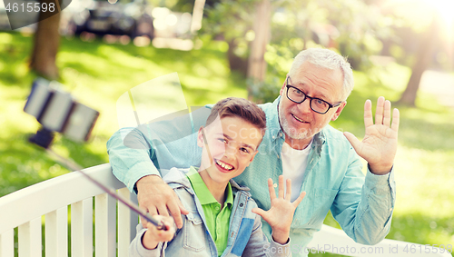 Image of old man and boy taking selfie by smartphone