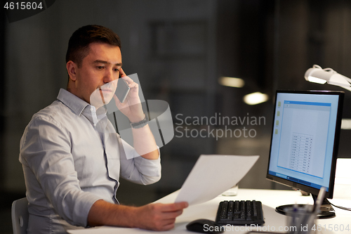 Image of businessman calling on sartphone at night office