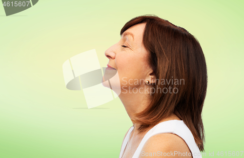 Image of profile of smiling senior woman over lime green