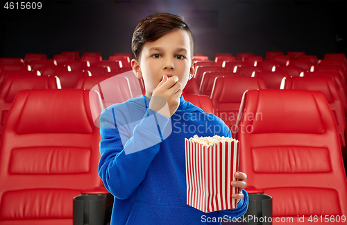 Image of boy in blue hoodie eating popcorn at movie theater