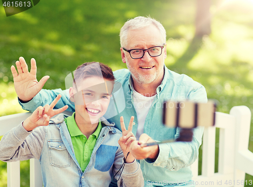 Image of old man and boy taking selfie by smartphone