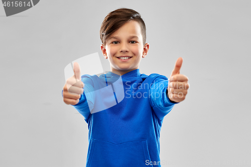 Image of smiling boy in blue hoodie showing thumbs up