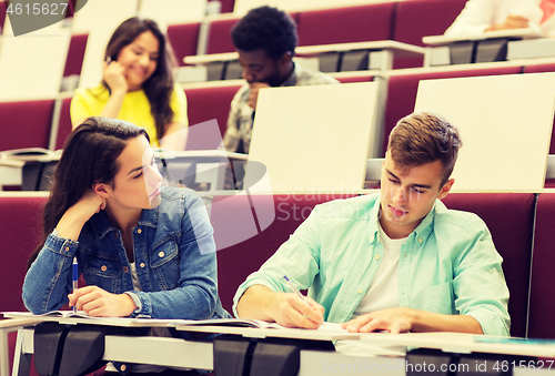 Image of group of students with notebooks in lecture hall