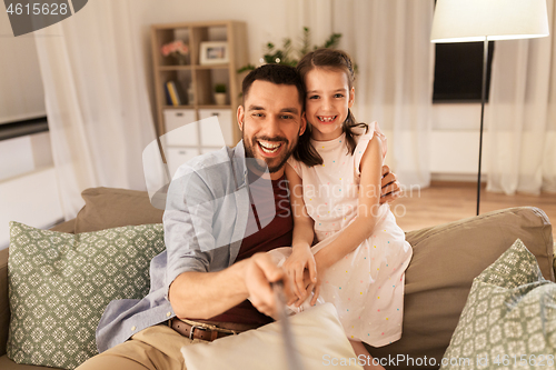 Image of father and daughter taking selfie at home