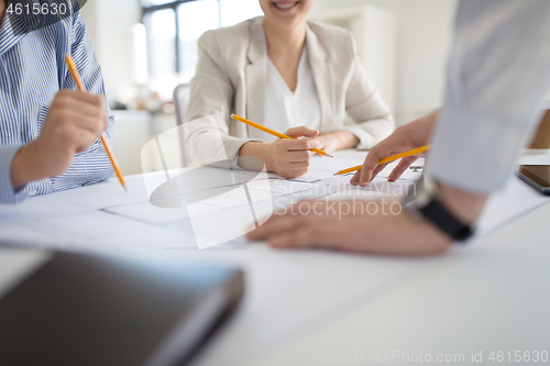 Image of close up of architects with blueprint at office