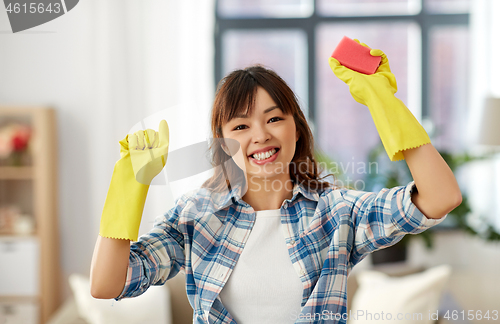 Image of happy asian woman with sponge cleaning at home