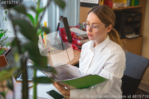 Image of Caucasian entrepreneur, businesswoman, manager working concentrated in office