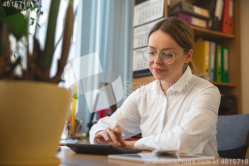 Image of Caucasian entrepreneur, businesswoman, manager working concentrated in office