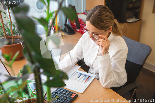 Image of Caucasian entrepreneur, businesswoman, manager working concentrated in office