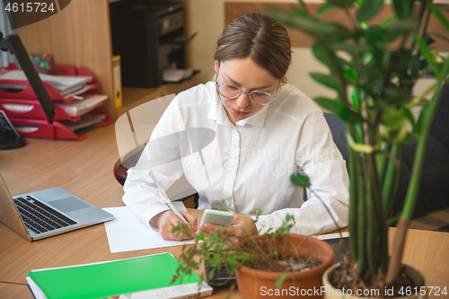 Image of Caucasian entrepreneur, businesswoman, manager working concentrated in office