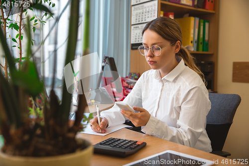 Image of Caucasian entrepreneur, businesswoman, manager working concentrated in office