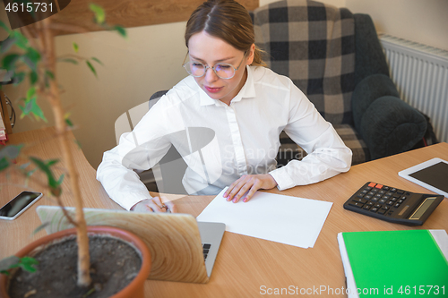 Image of Caucasian entrepreneur, businesswoman, manager working concentrated in office