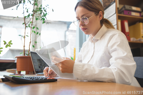 Image of Caucasian entrepreneur, businesswoman, manager working concentrated in office