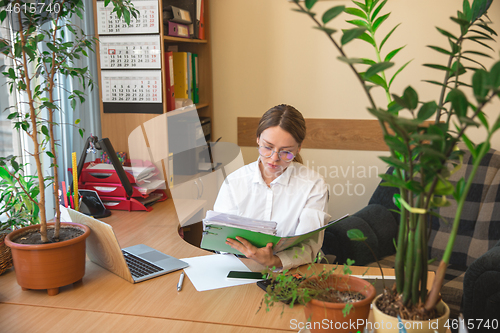 Image of Caucasian entrepreneur, businesswoman, manager working concentrated in office