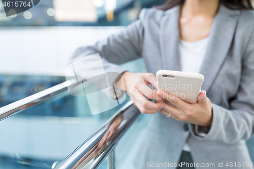 Image of Businesswoman sending text message on mobile phone