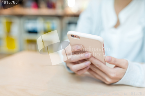 Image of Woman working on cellphone on table