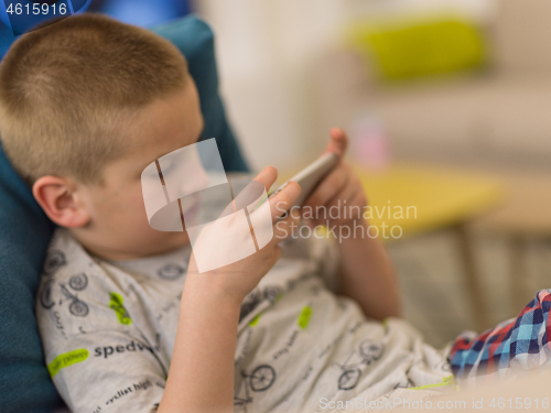 Image of little boy playing games on smartphone